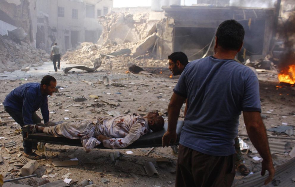 Voluntarios trasladan a un civil herido en un ataque aéreo del régimen sirio en Alepo (Reuters).