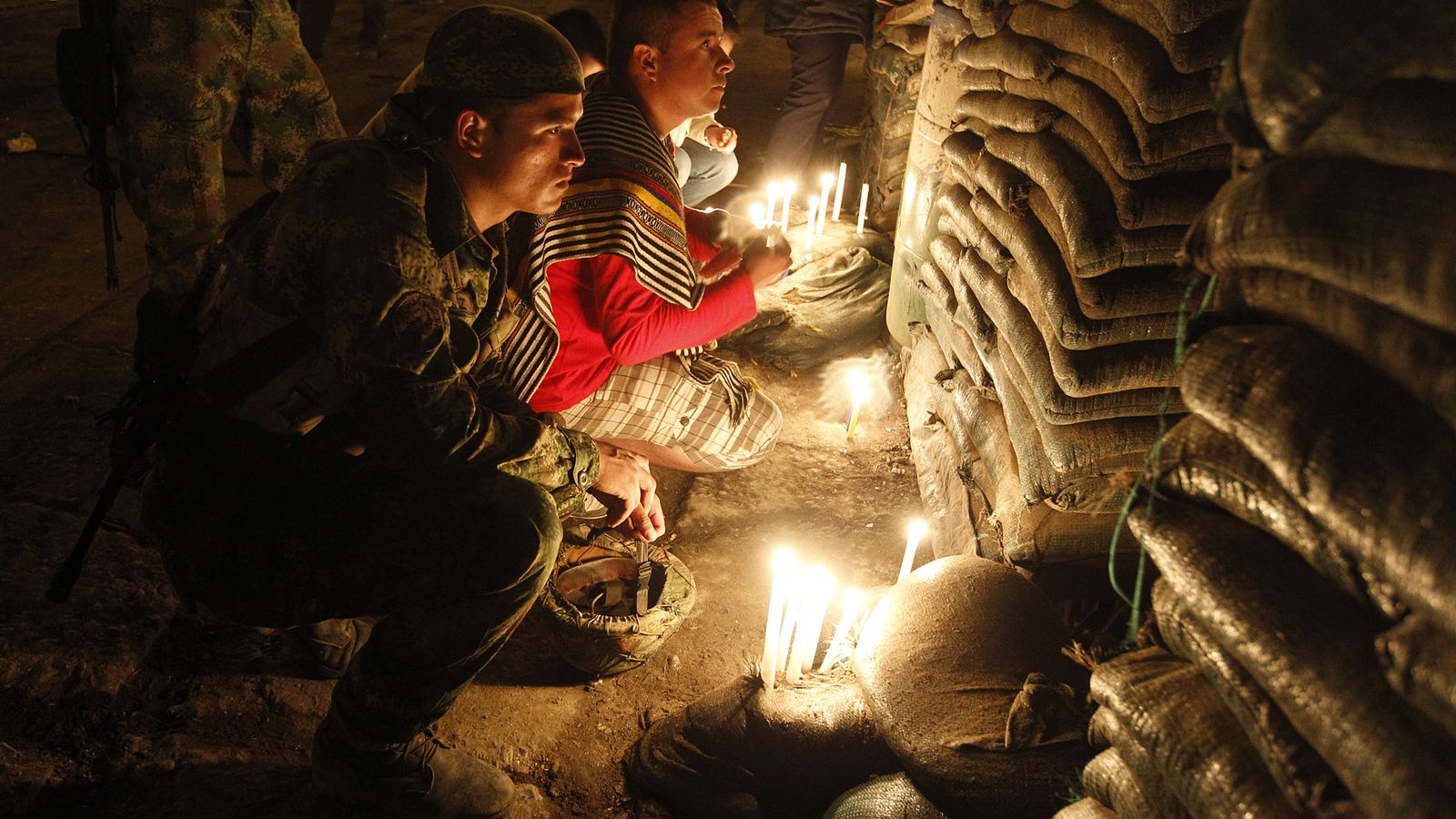 Foto: Un soldado colombiano enciende velas en memoria a camaradas muertos en un atentado en Inza, Cauca (Reuters).