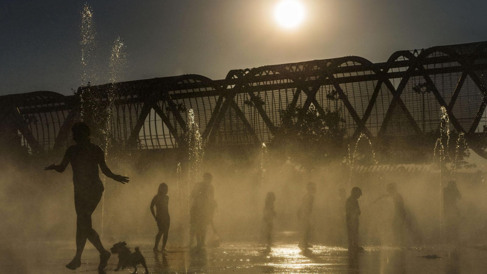 Foto: Varias personas se refrescan en las fuentes de Madrid Río de la capital. (Efe)