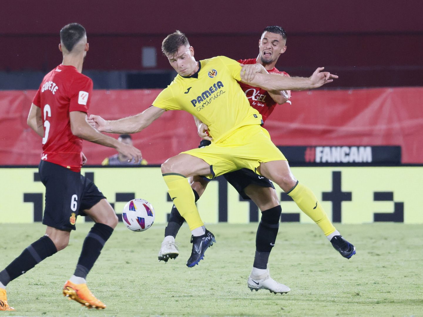 El defensa del Villarreal Jorge Cuenca (c) disputa una posesión ante Copete (i), y Jaume Costa (d), ambos del Mallorca (EFE/CATI CLADERA)