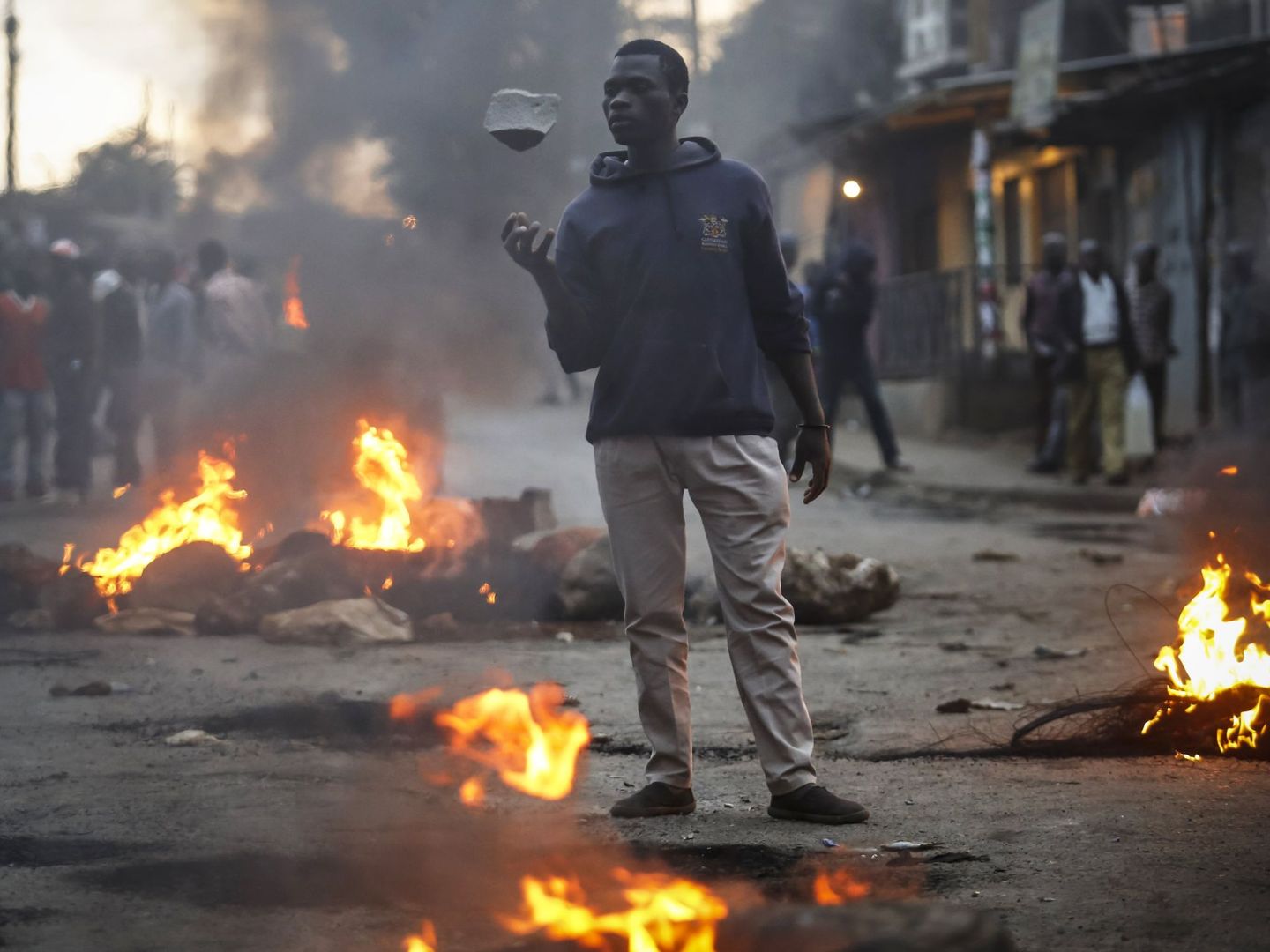 Seguidores del líder de la oposición, Raila Odinga, lanzan piedras a los seguidores del actual presidente, Uhuru Kenyatta, durante una protesta (EFE)