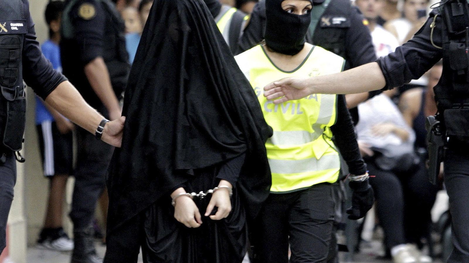 Foto: Una supuesta yihadista sale de su domicilio en Gandía detenida por la Guardia Civil. (EFE)