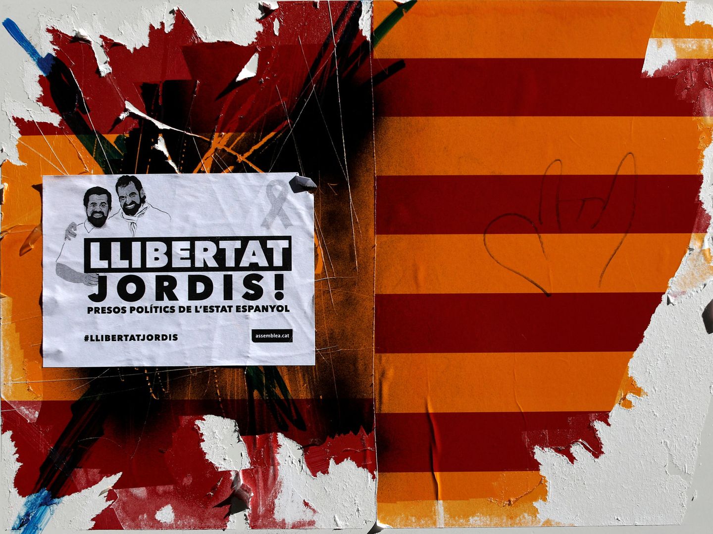 Una pared en Barcelona en la que la pegatina de los Jordis se sobrepone a las banderas catalana y española. (Reuters/Gonzalo Fuentes)