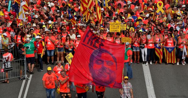 Foto: Manifestantes ondean una pancarta con la imagen de Junqueras durante la Diada. (Reuters)
