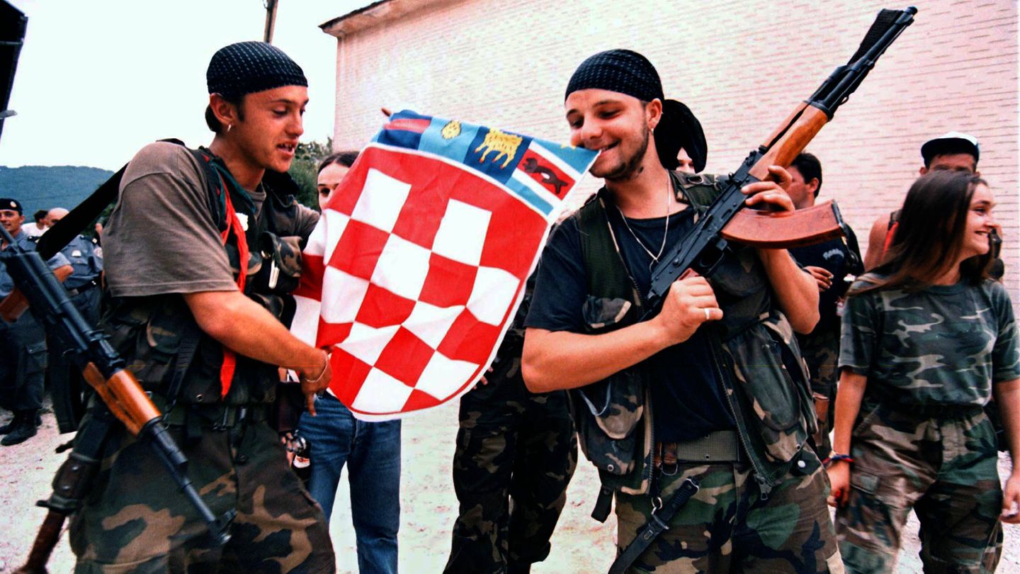 Soldados croatas despliegan una bandera tras capturar la localidad de Slunj en 1995. (Reuters)