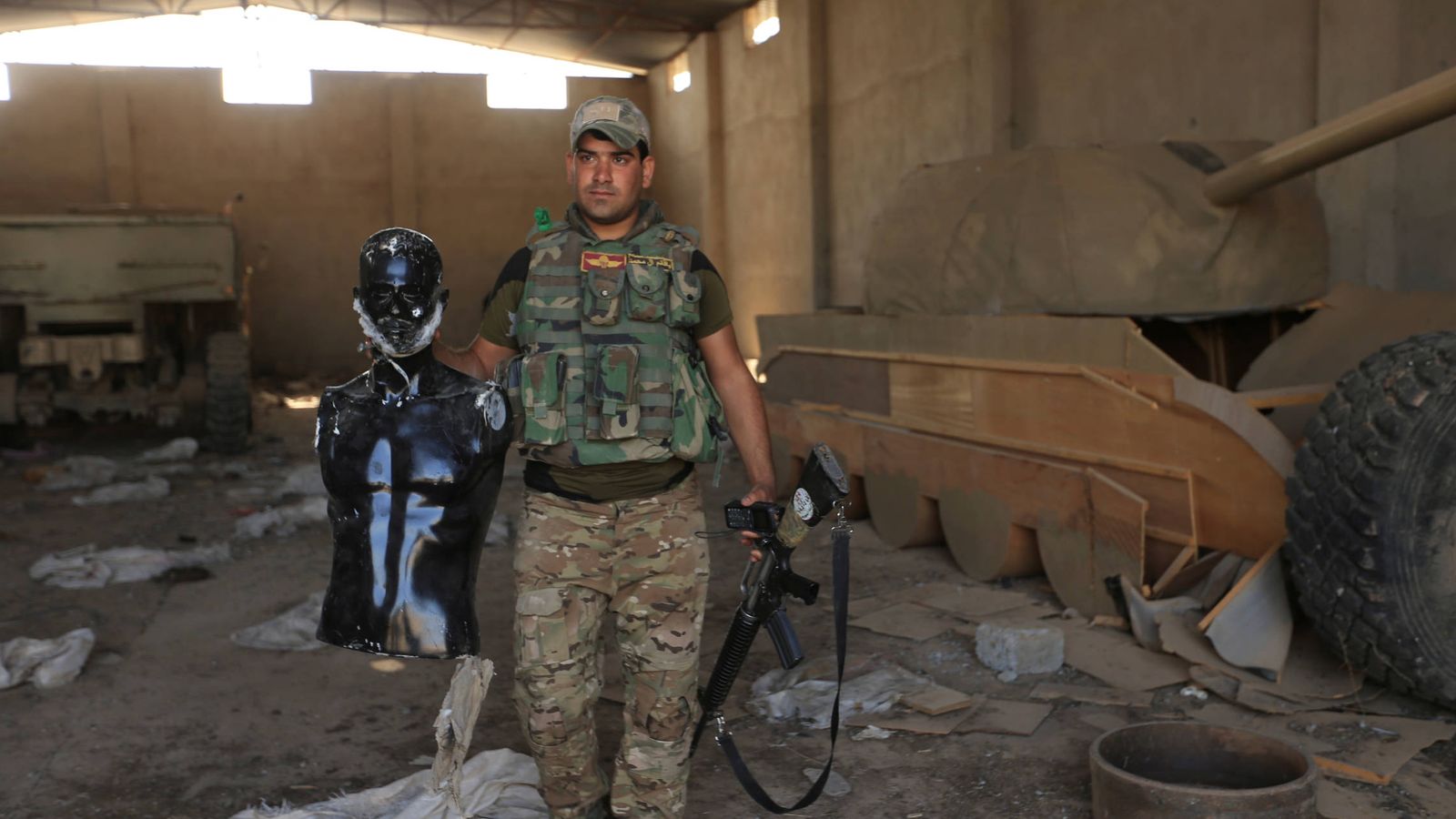 Foto: Un soldado iraquí muestra un maniquí ante un tanque de madera en Bawiza, al norte de Mosul (Reuters).
