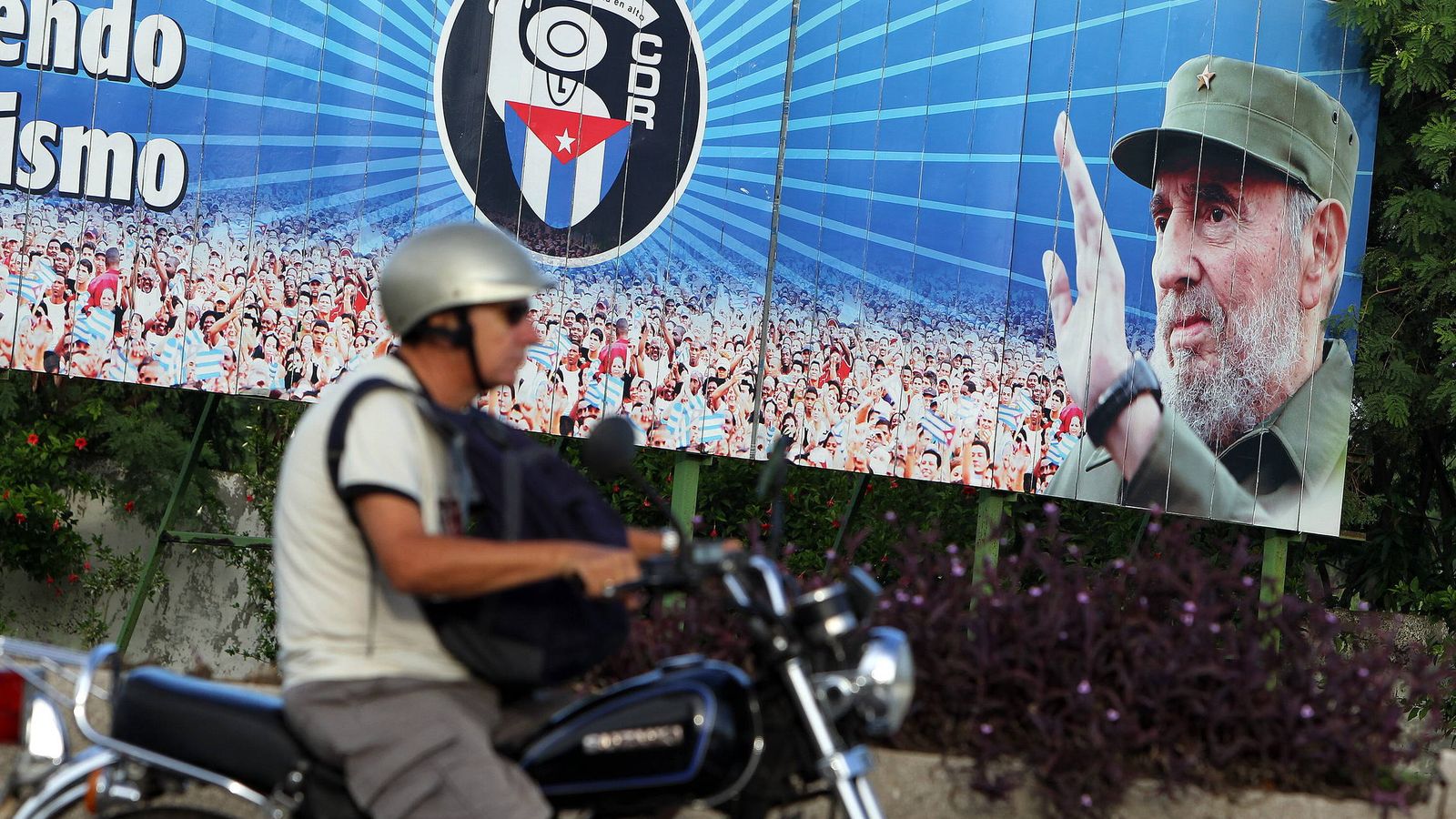 Foto: Un motociclista pasa frente a un cartel con la imagen de Fidel Castro, en La Habana (Cuba).