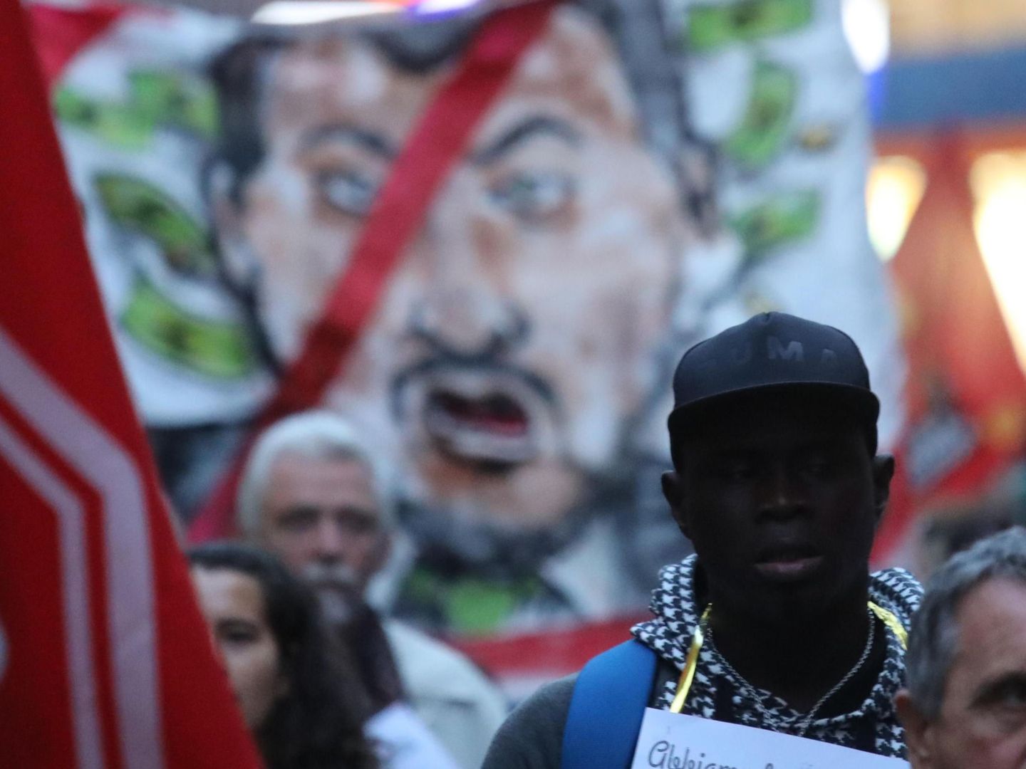 Protesta en Calabria contra la detención del alcalde pro-inmigración de Riace, con una imagen de Salvini al fono (EFE)