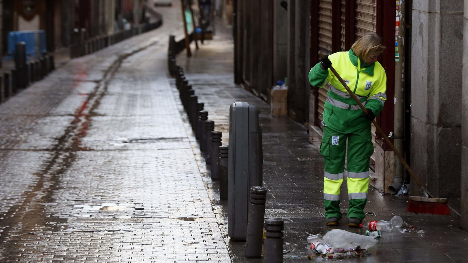 Foto: Una trabajadora de los Servicios de Limpieza de Madrid recoge las basuras y desperdicios que quedan en las inmediaciones de la Puerta del Sol de Madrid (Efe)