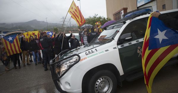 Foto: Un vehículo de la Guardia Civil entre banderas independentistas, este viernes en la imprenta Artyplan de Sant Feliu de Llobregat. (EFE)