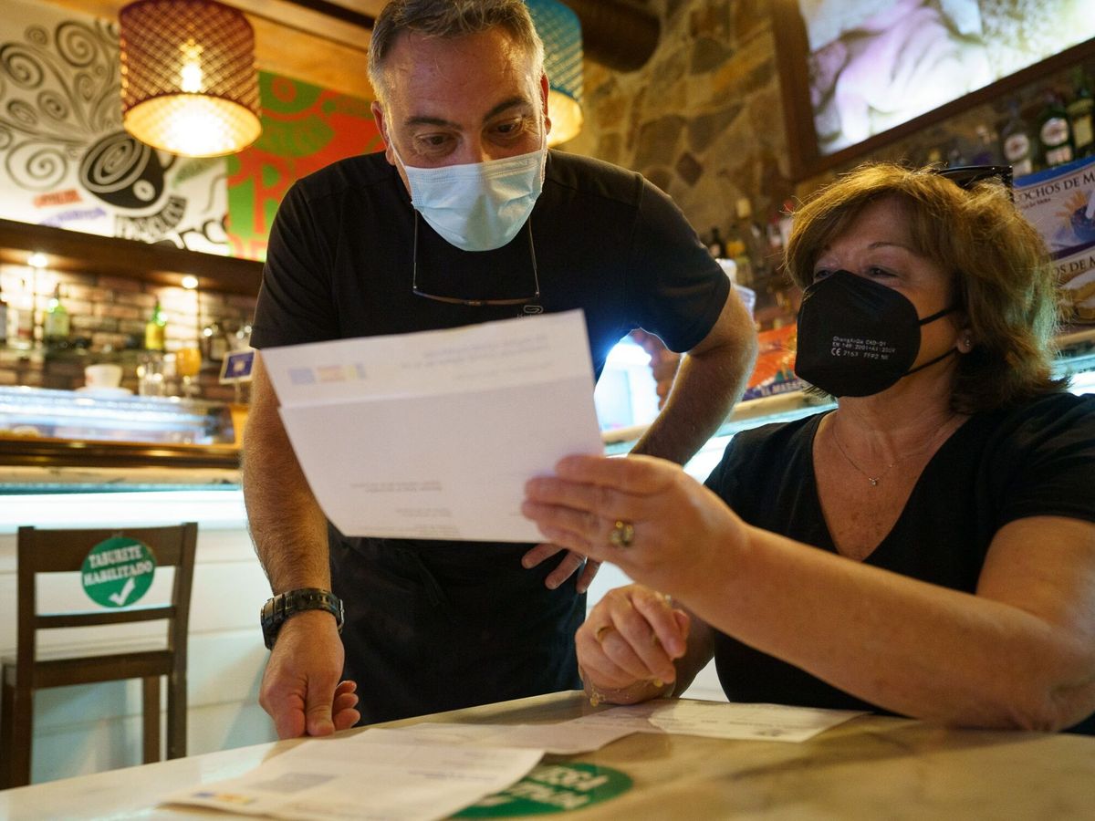 Foto: Personal de una cafetería de Santa Cruz de Tenerife comprueba el certificado covid de una clienta. (EFE/Ramón de la Rocha)