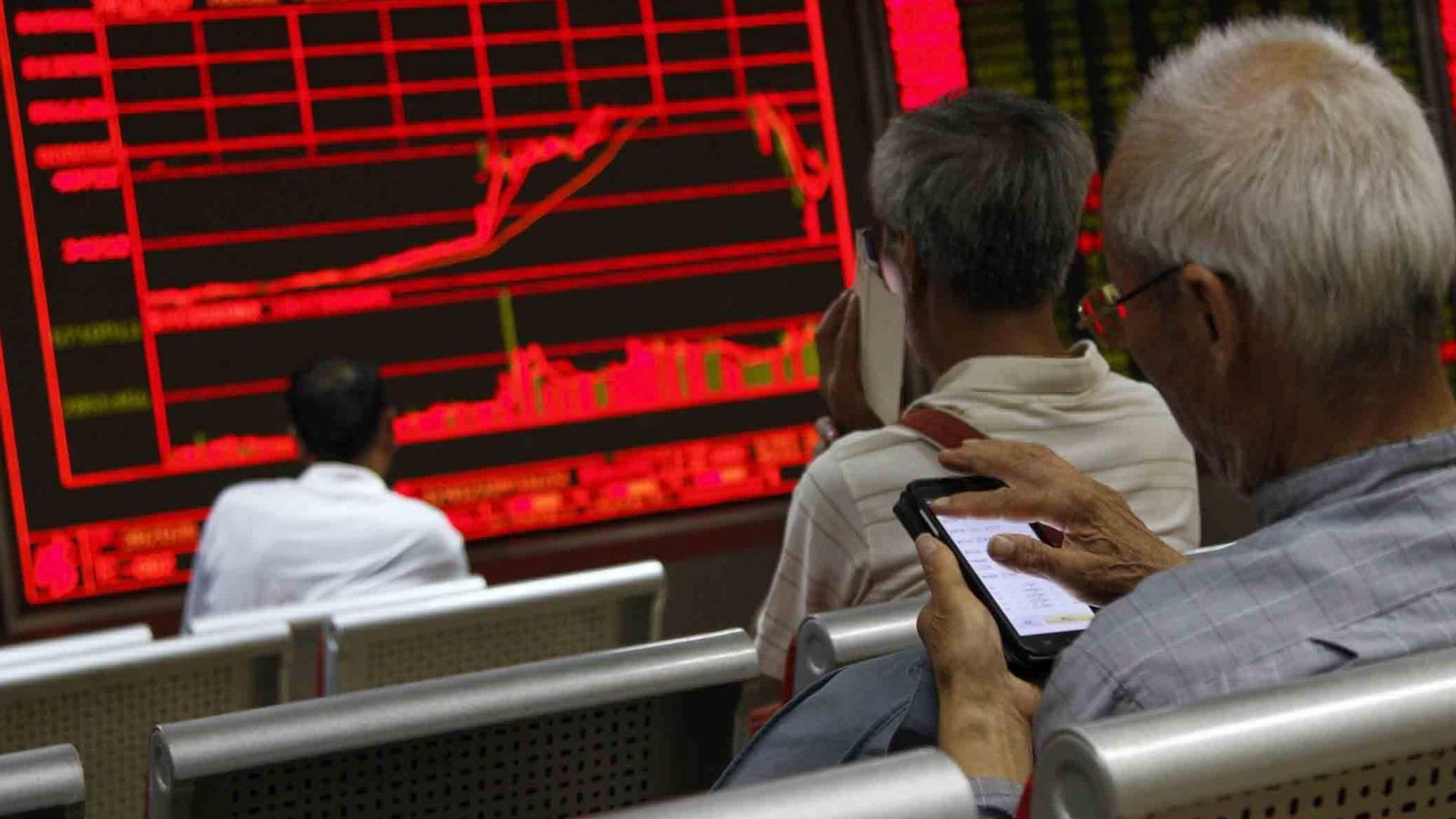 Foto: Varias personas monitorizan la evolución de la bolsa de Shangai. (Reuters)