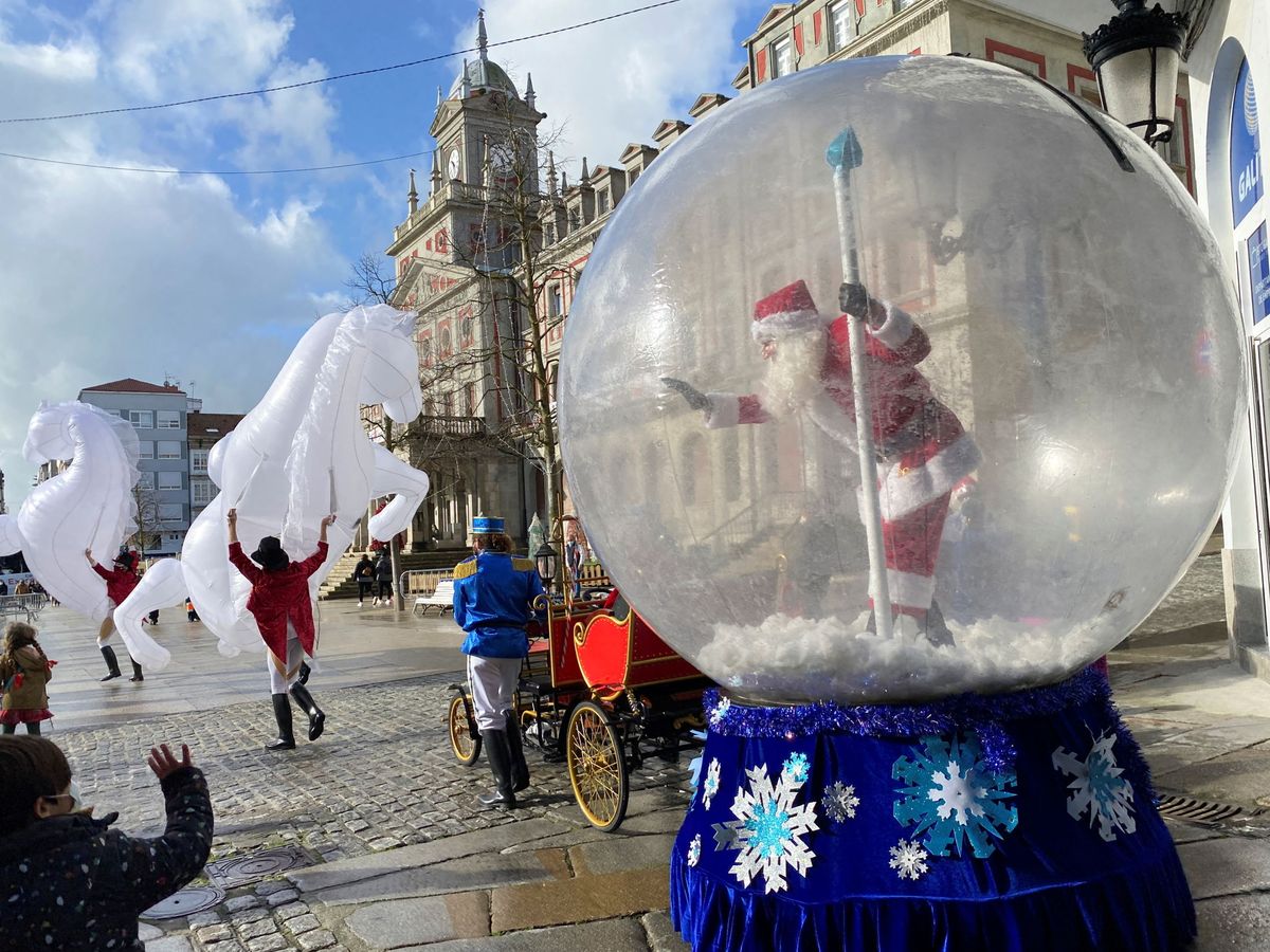 Foto: Papá Noel saluda a los niños desde una burbuja en una plaza de Ferrol. (EFE)