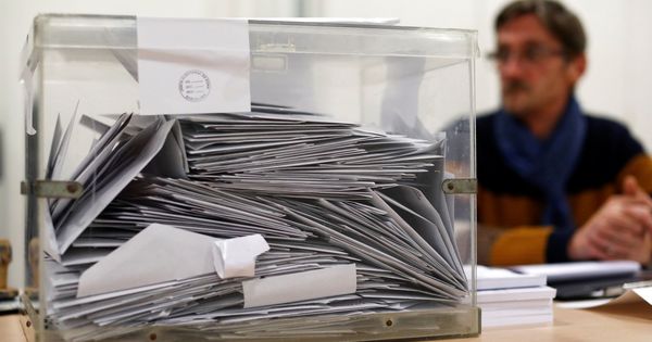 Foto: Un miembro de una mesa electoral, sentado tras una urna. (Reuters)