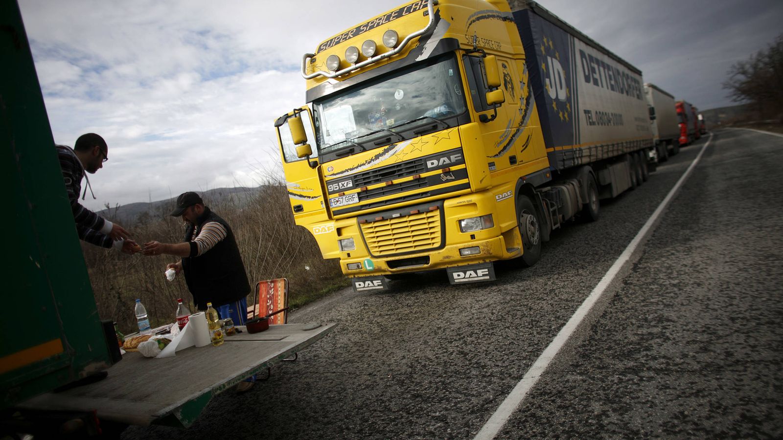 Foto: Camioneros de Europa del Este preparan su almuerzo en una cuneta. (Reuters)