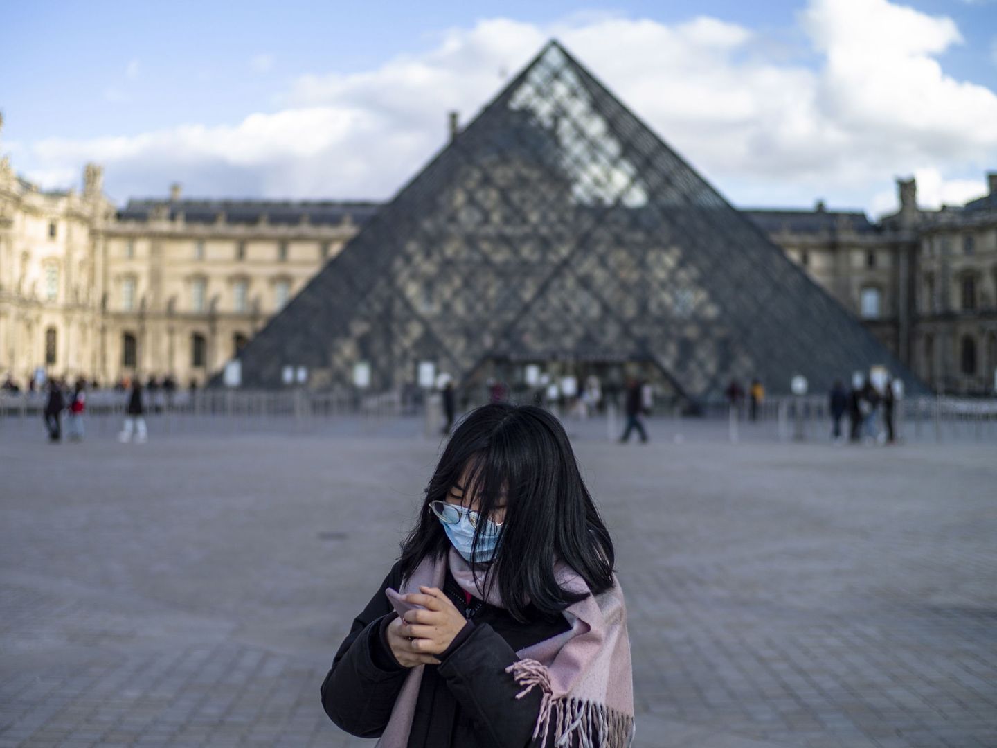 Una persona con mascarilla frente al Museo del Louvre, en París. (Reuters)