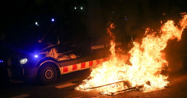 Foto: Un coche policial atraviesa una barricada en llamas. (Reuters)