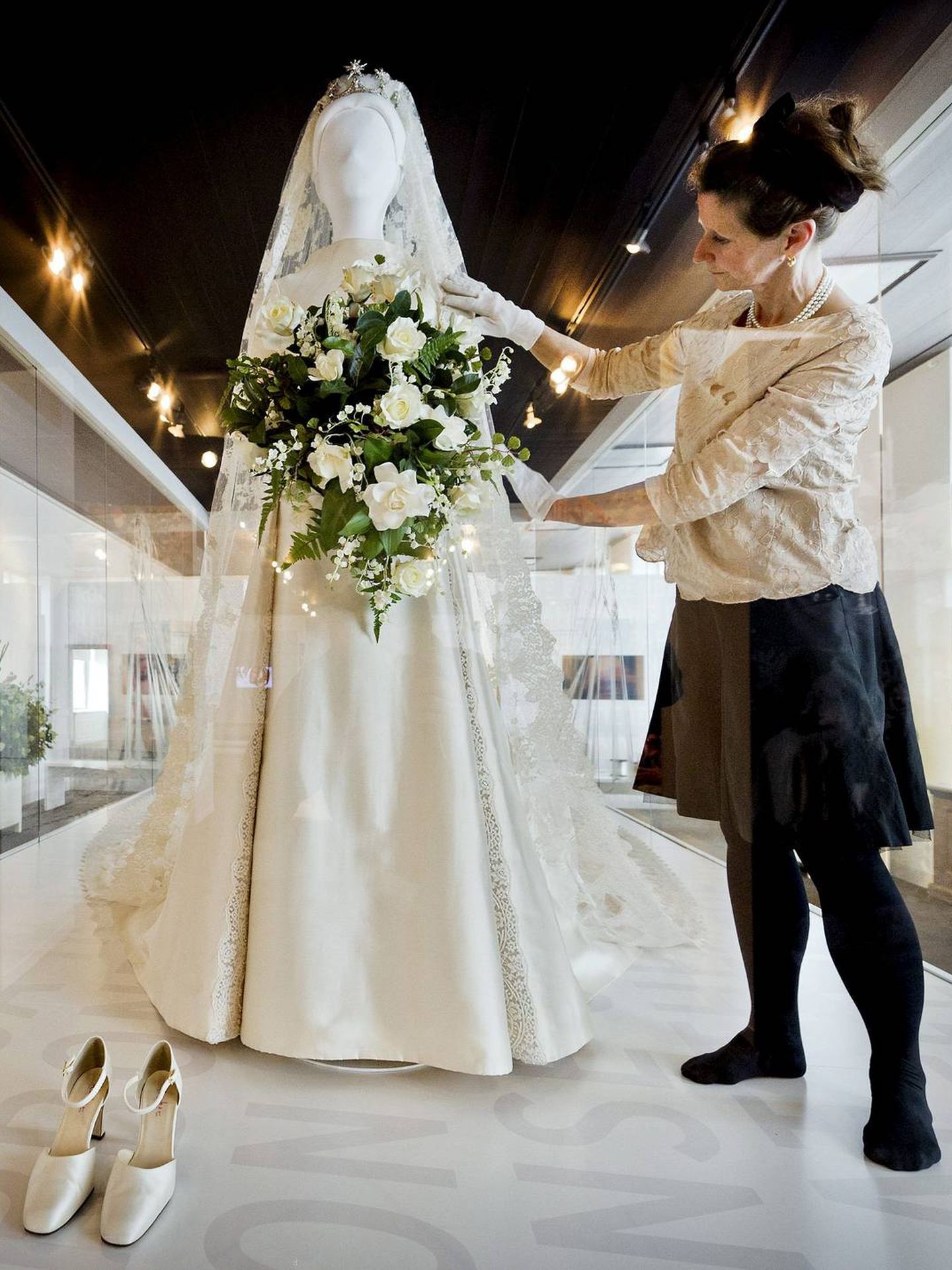 Una asistente coloca en un maniquí el vestido de novia de Máxima de Holanda. (EFE)