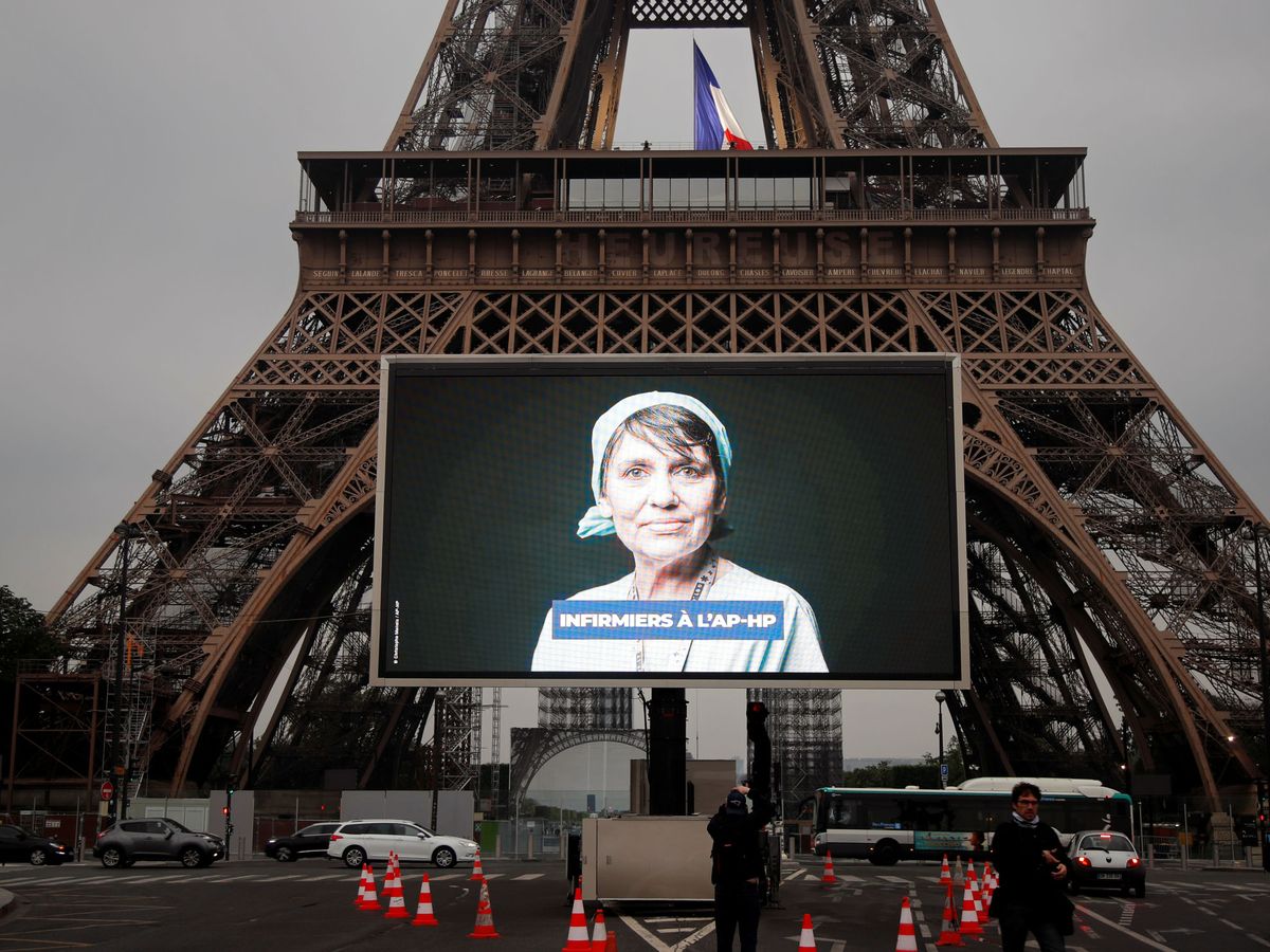 Foto: Una pantalla reproduce mensajes sobre el coronavirus frente a la torre Eiffel. (Reuters)