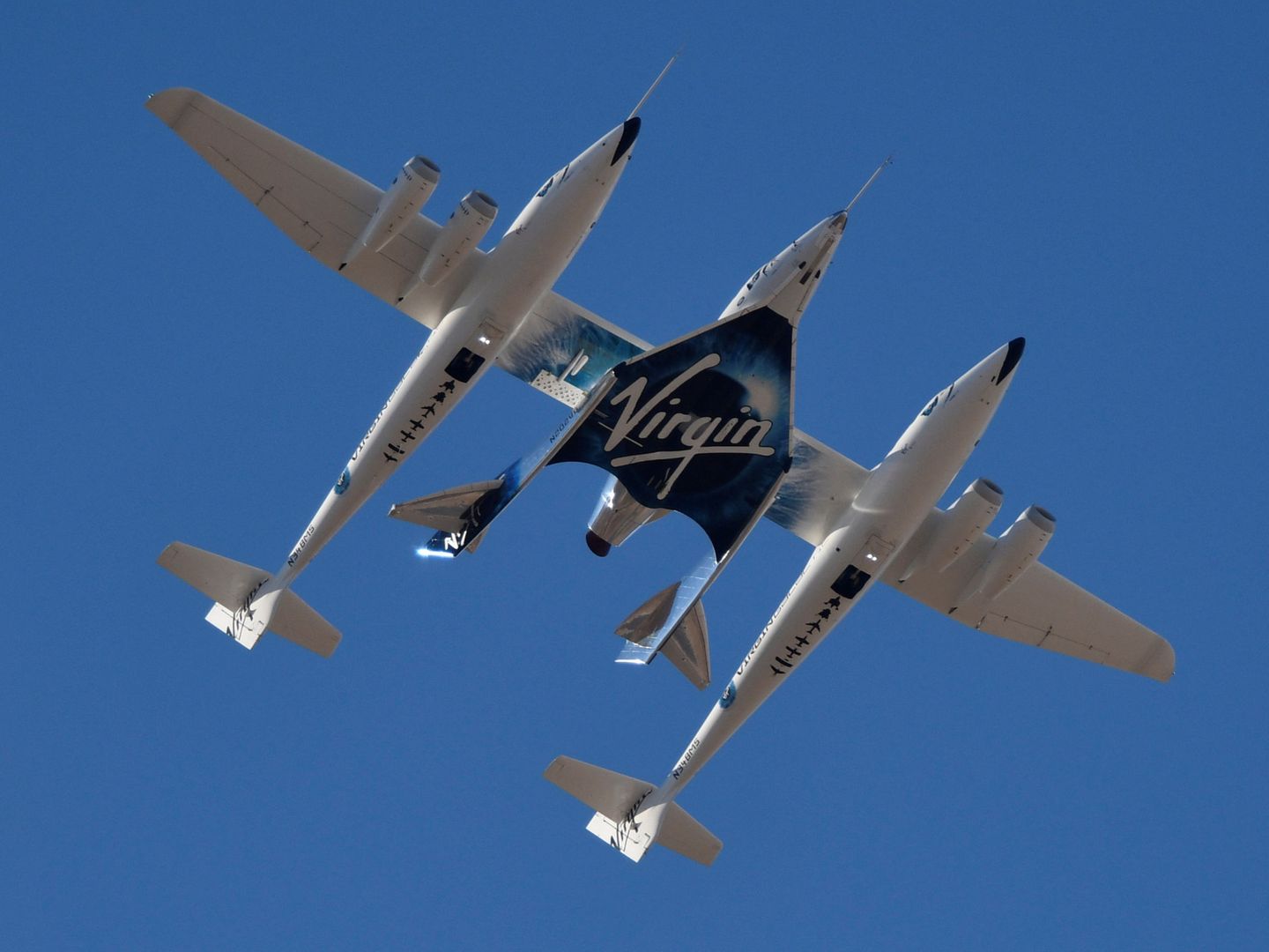 El transporte espacial de Virgin Galactic, en el centro, en uno de sus vehículos de soporte. (Reuters)