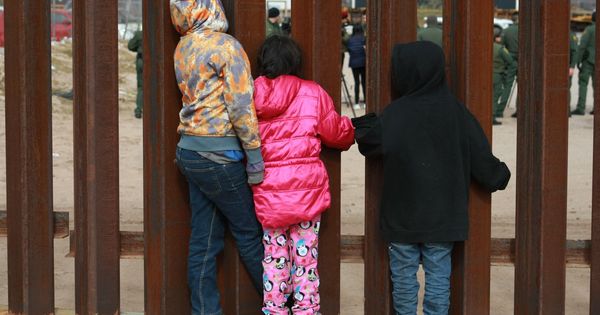 Foto: Un grupo de niños observan a agentes de migración de Estados Unidos en el muro fronterizo en la ciudad de Tijuana. (EFE)