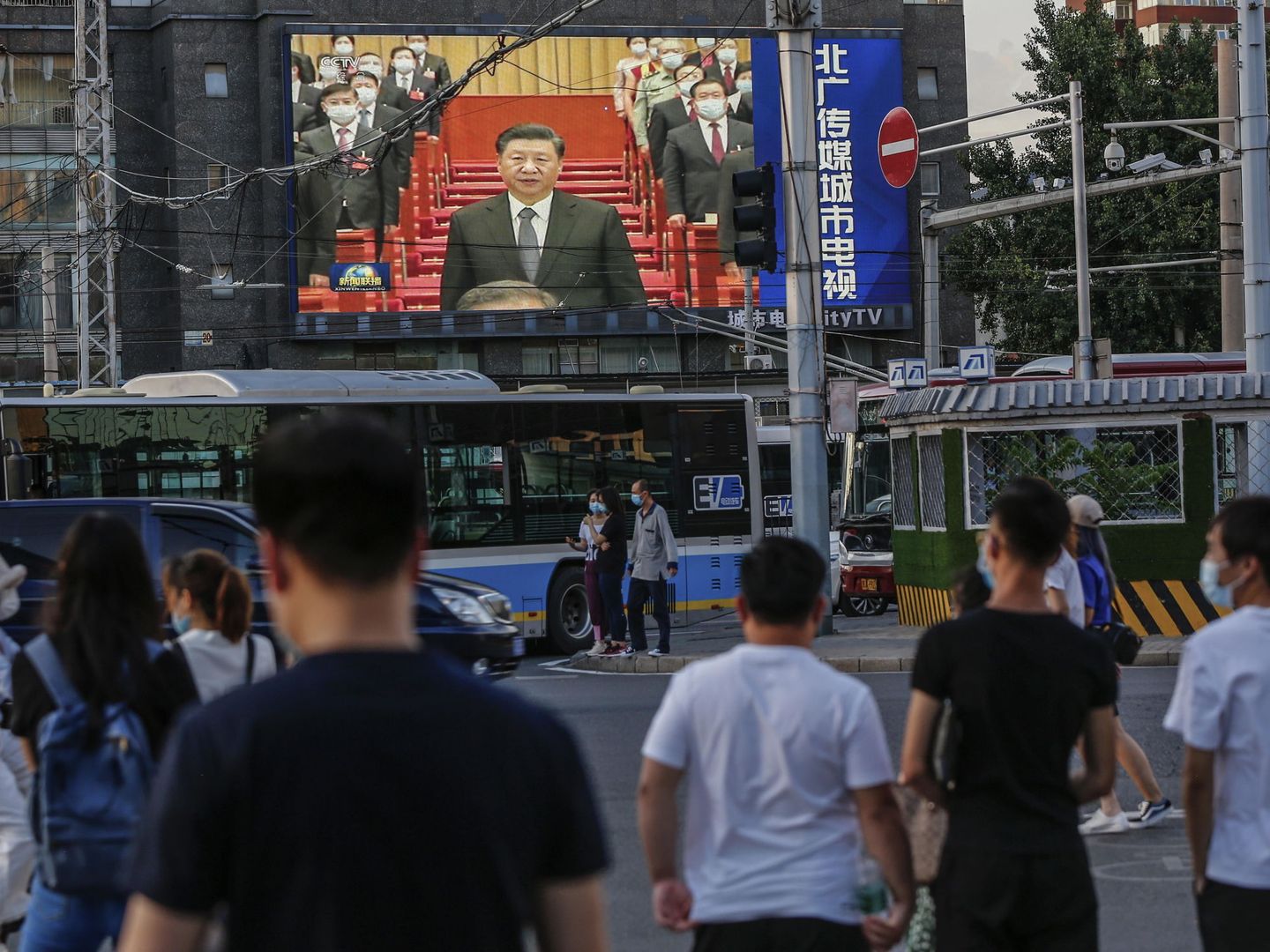 Un grupo de personas mira unas pantallas con un discurso del presidente Xi Jinping. (Reuters)