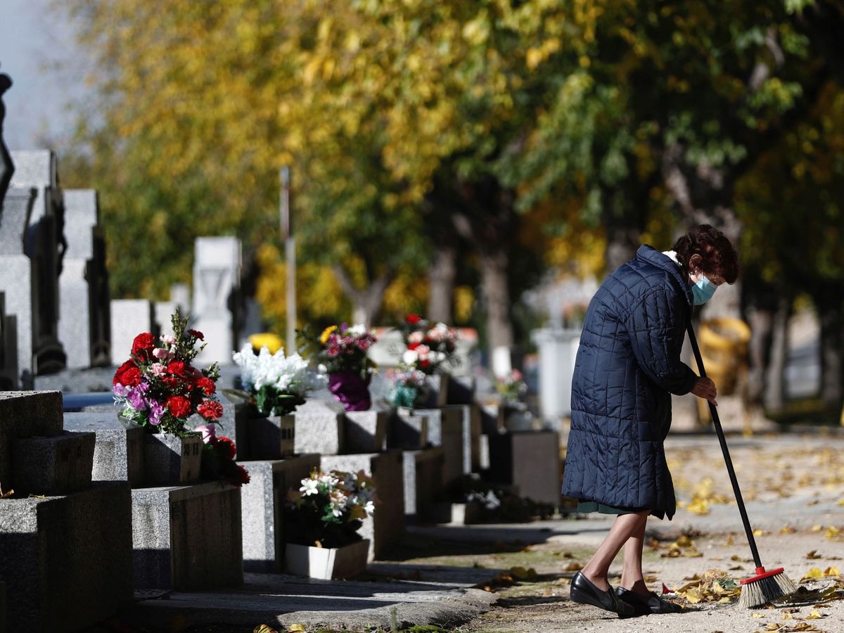 Foto: Una mujer visita la tumba de un familiar en el cementerio de la Almudena. (EFE/Mariscal)