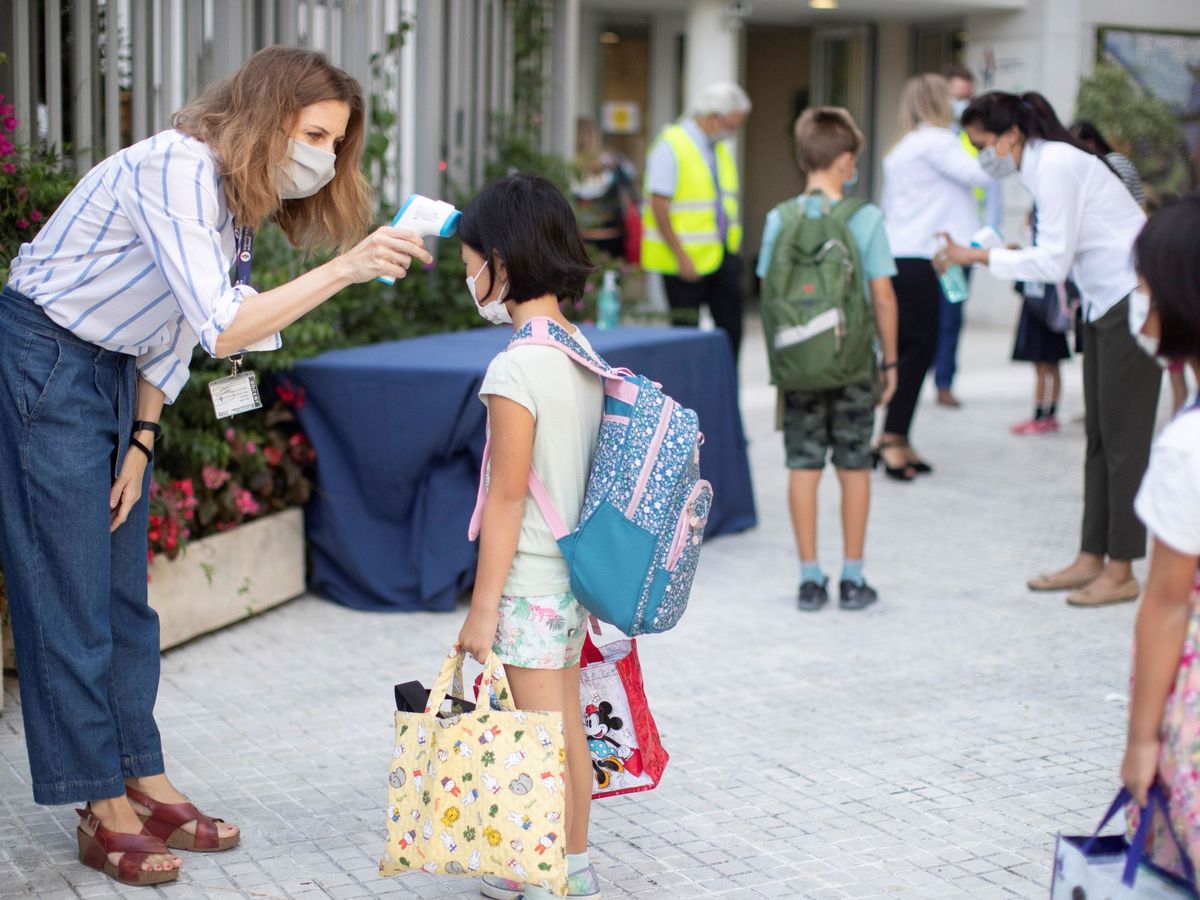 Foto: Una trabajadora toma la temperatura a una niña a la entrada del colegio privado en Barcelona. (EFE)