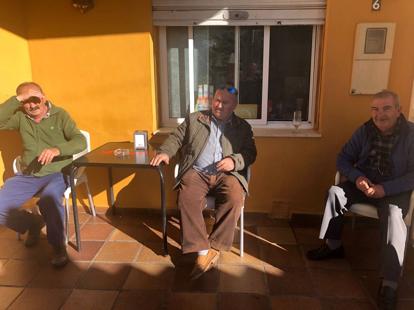Miguel Santiago, a la derecha, con dos amigos, en la terraza del bar Arriba y Abajo. (Agustín Rivera)
