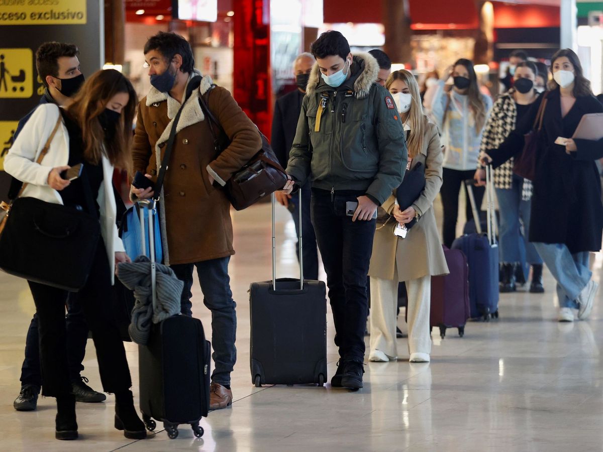 Foto: Varios viajeros hacen cola ante un mostrador de facturación en el aeropuerto Adolfo Suárez Madrid-Barajas. (EFE)