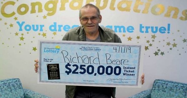 Foto: Richard Beare con la foto en la que posa como ganador del premio de 250.000 dólares (Foto: North Carolina Education Lottery)