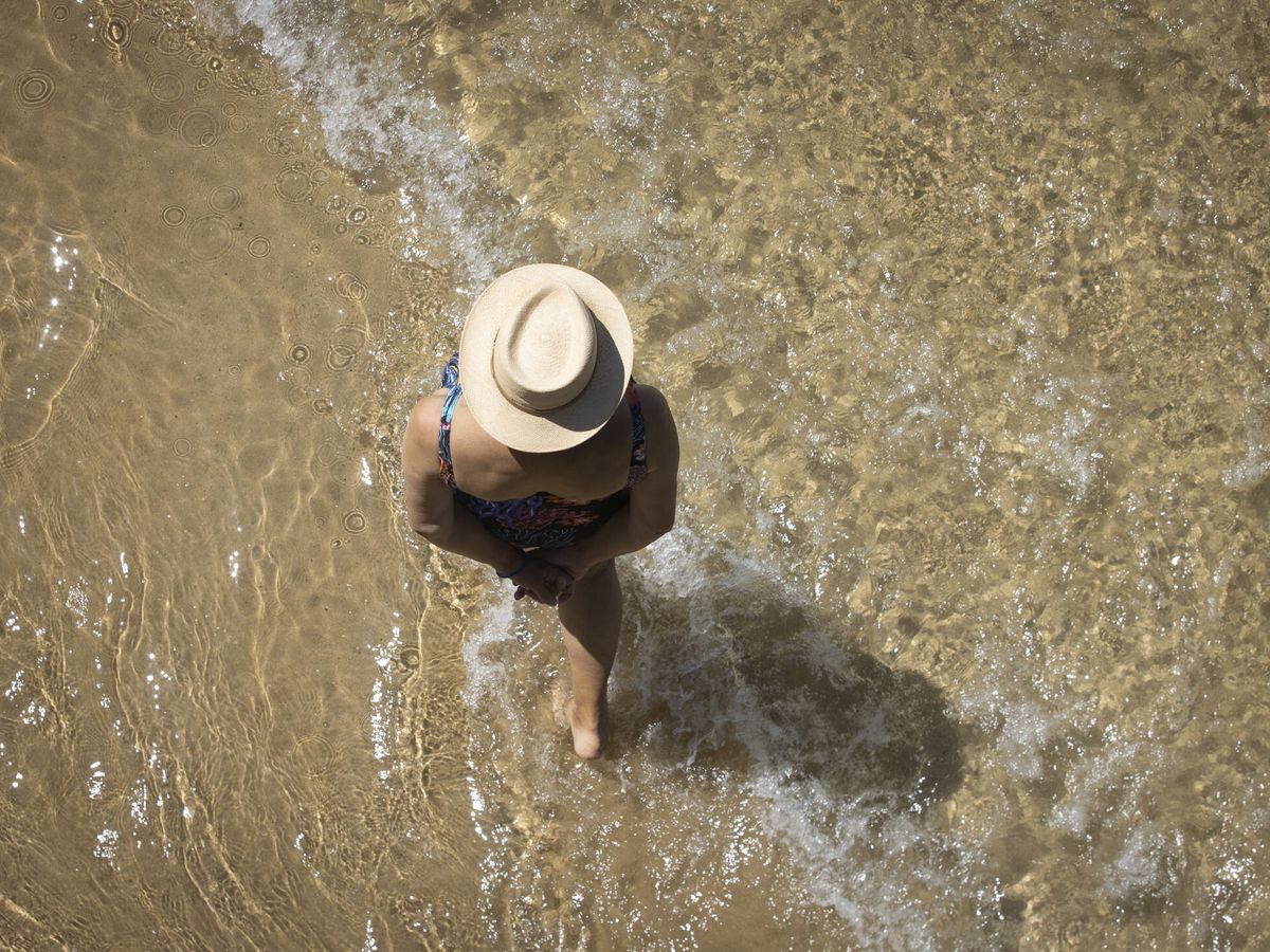 Foto: Una mujer pasea por la orilla de la playa de La Concha de San Sebastián. (EFE/Javier Etxezarreta)