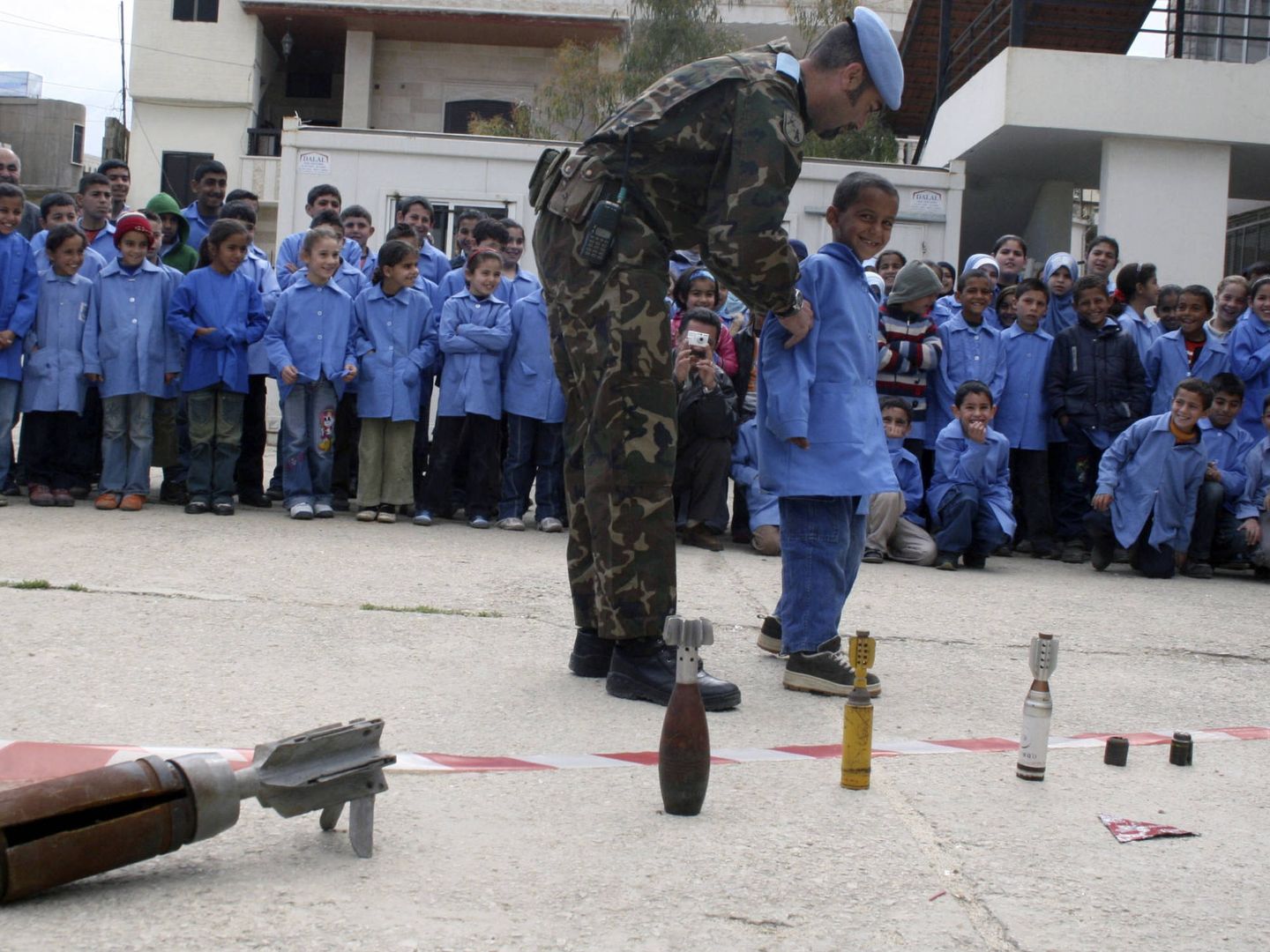 Un soldado español enseña a niños libaneses los riesgos de minas sin estallar, en el pueblo de Khiam. (Reuters)
