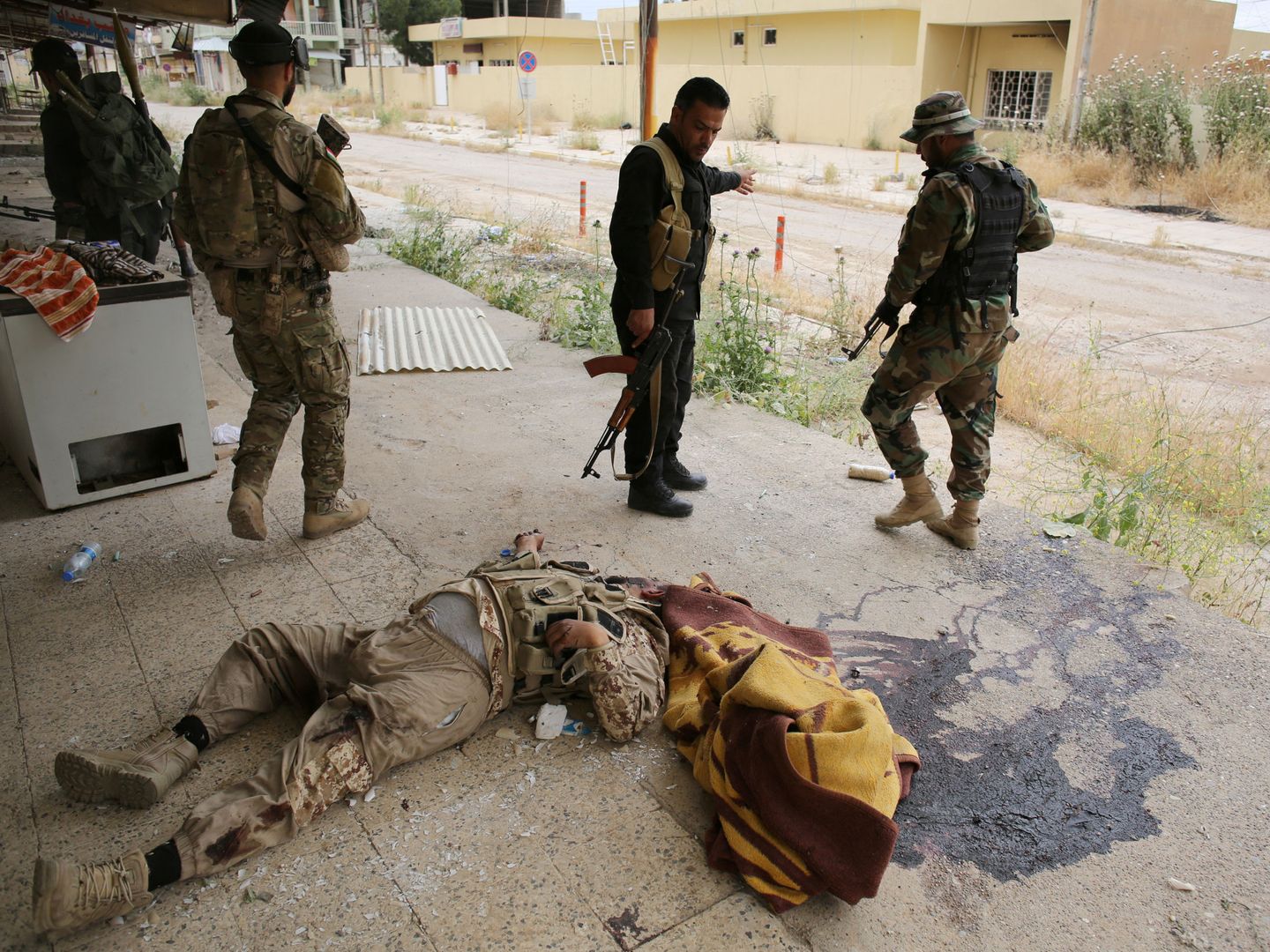 Combatientes peshmerga observan el cadáver de un militante del Daesh en Tel Asof, el 4 de mayo de 2016 (Reuters)