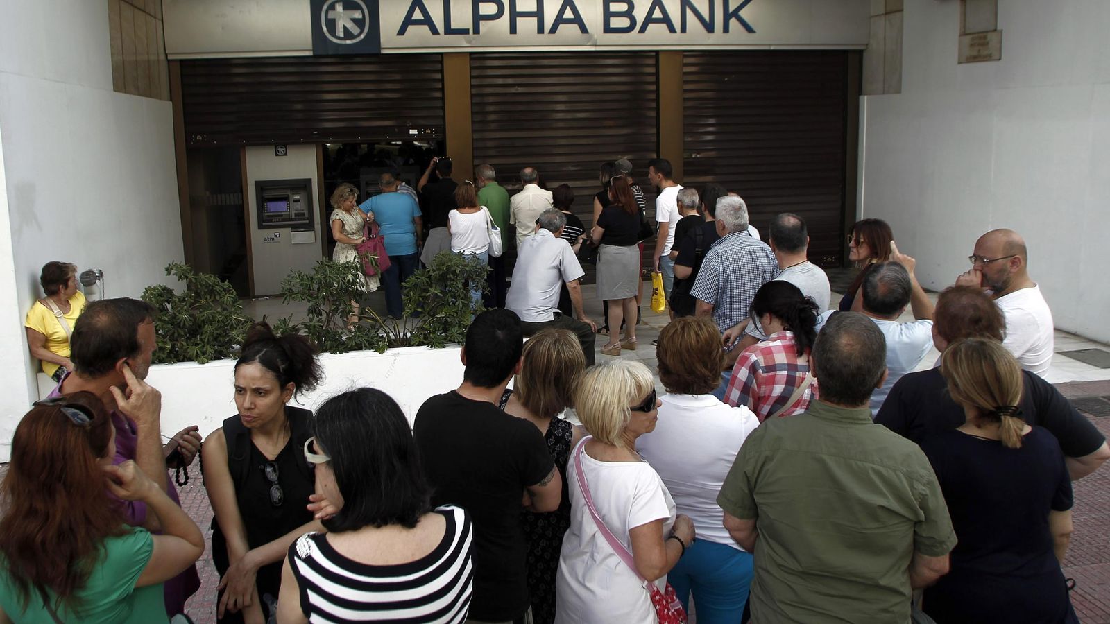 Foto: Ciudadanos griegos hacen cola a la puerta de un banco (Reuters)