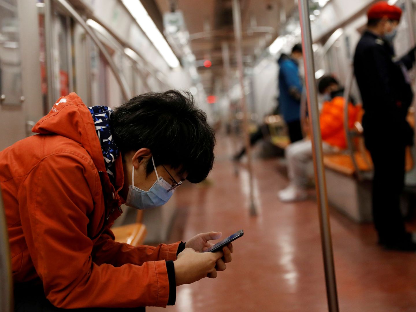 Un hombre ataviado con mascarilla mira su móvil en Pekín. (Reuters)