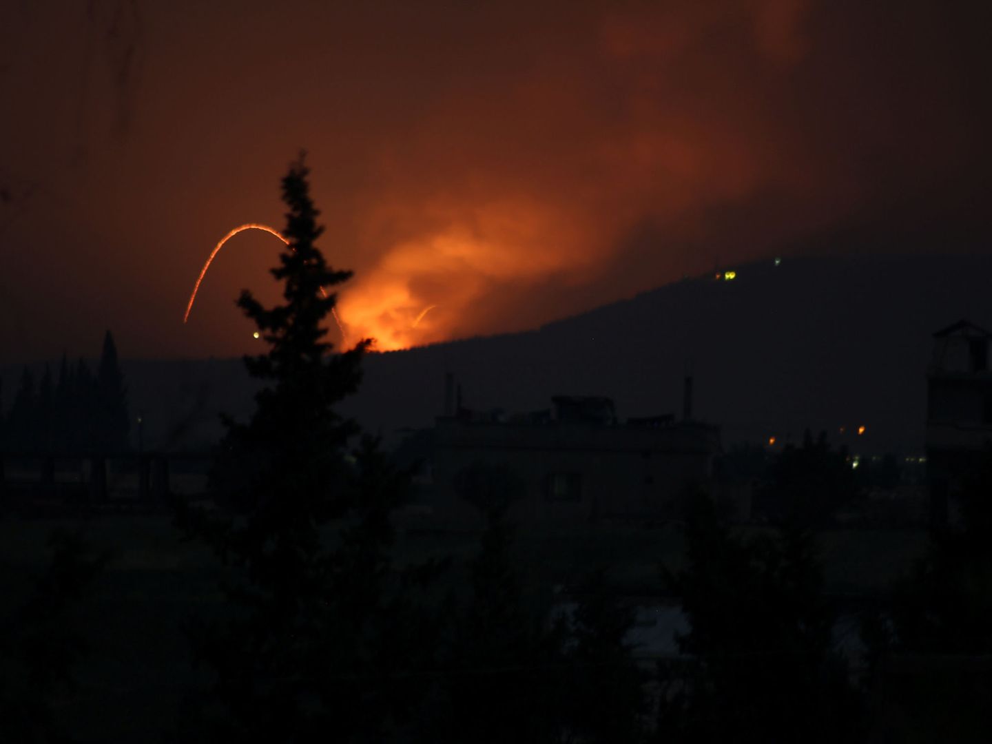 Fuego y explosiones en lo que parece ser un ataque con misiles contra una base militar utilizada por fuerzas iraníes al sur de Hama, en Siria, el 29 de abril de 2018. (Reuters)