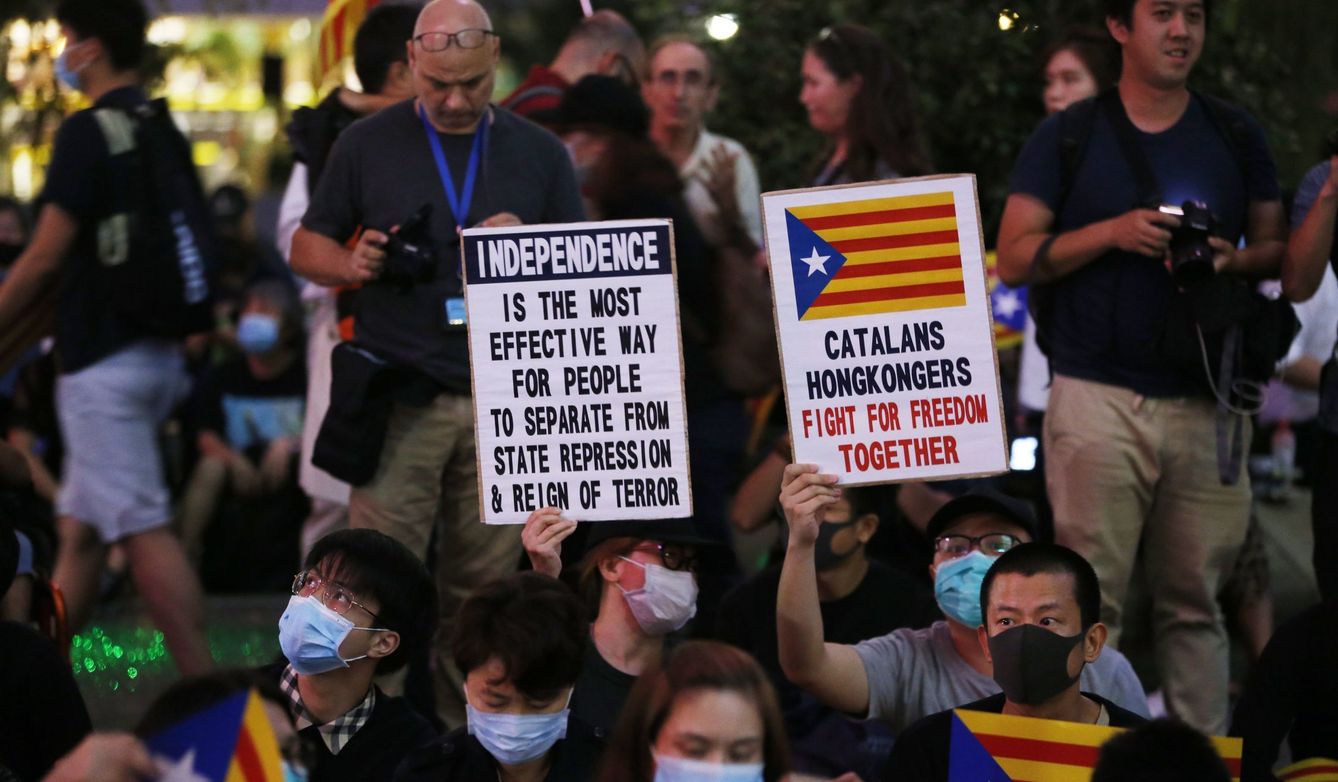 Varios manifestantes de Hong Kong muestran carteles a favor de la independencia en Cataluña. (Reuters)
