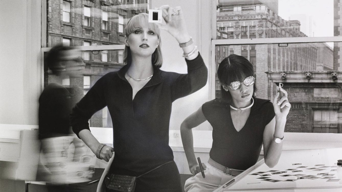 Foto: Dos modelos en un oficina mirando negativos, foto de 1976 de Duane Michals. Vogue © Condé Nast