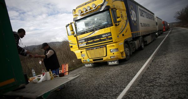 Foto: Camioneros de Europa del Este preparan su almuerzo en una cuneta. (Reuters)