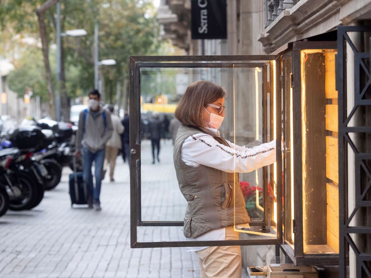 Foto: Una mujer ordena un escaparate en una tienda del centro de Barcelona. (EFE)