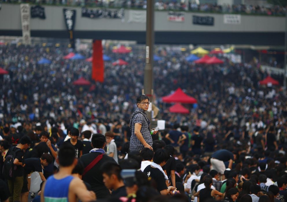 Foto: Un hombre observa a los manifestantes mientras bloquean este martes el distrito financiero de Hong Kong (Reuters).