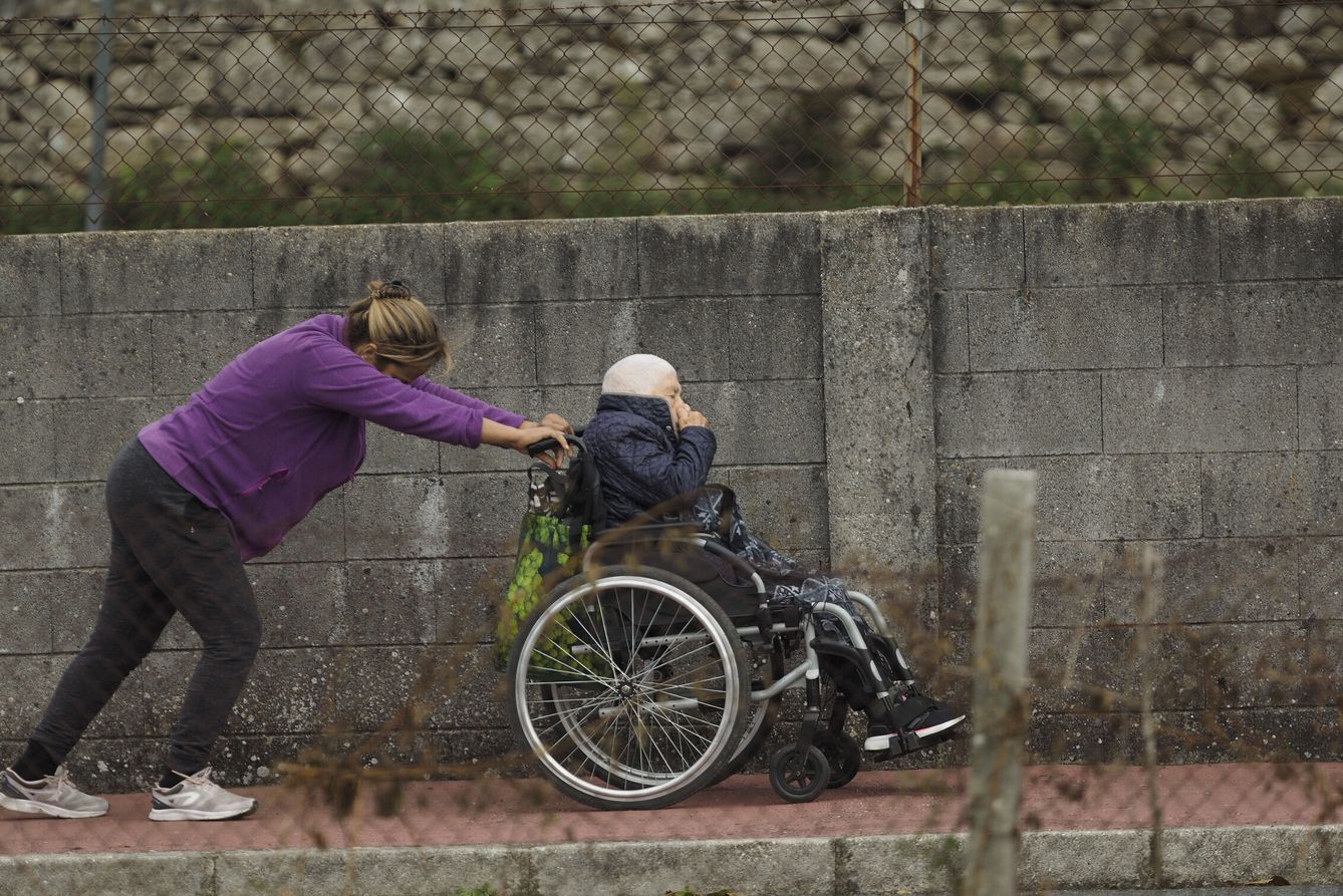Una cuidadora y una persona mayor, en una zona rural de la provincia de Lugo. (EFE/Eliseo Trigo)