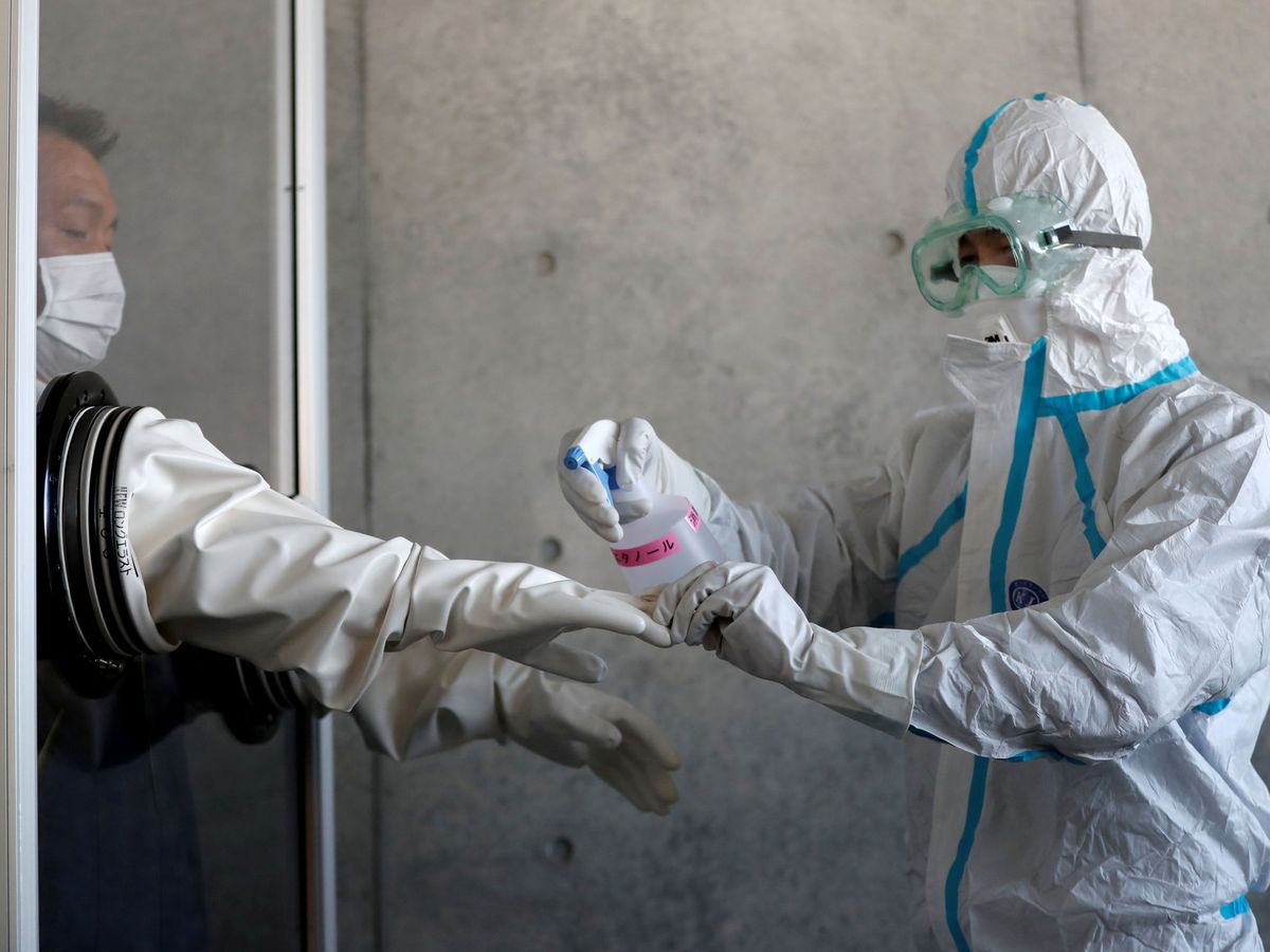 Foto: Personal sanitario desinfectándose tras realizar una PCR. (Reuters) 