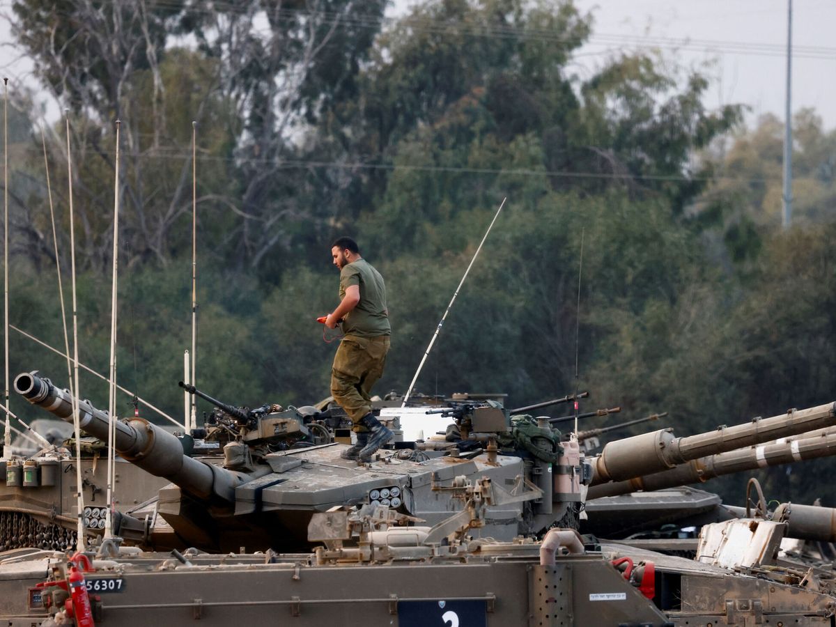 Foto: Un soldado israelí trabaja encima de un tanque en la frontera con el centro de Gaza. (Reuters/Amir Cohen)