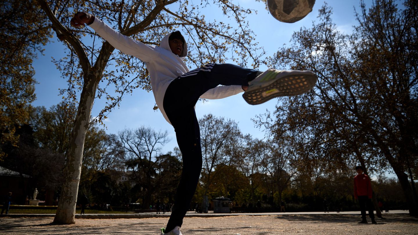 Un joven juega al fútbol en un parque de Madrid. (EFE/Miguel Oses)
