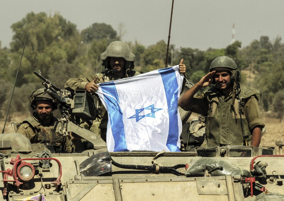 Foto: Soldados israelíes saludan desde su tanque, en la frontera de Gaza. (Efe)