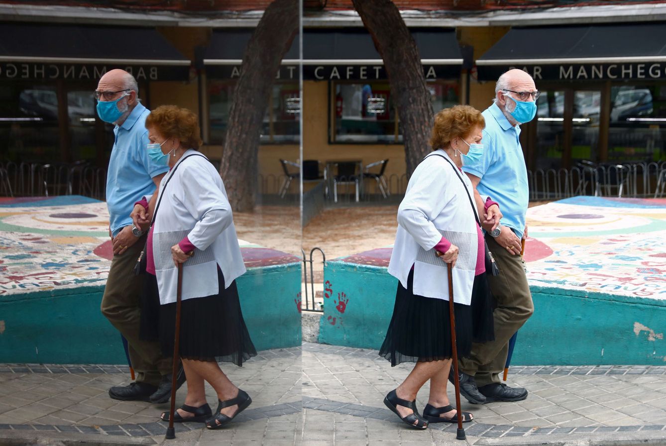 Una pareja de ancianos camina por una calle del barrio de Usera, en Madrid. (Reuters)