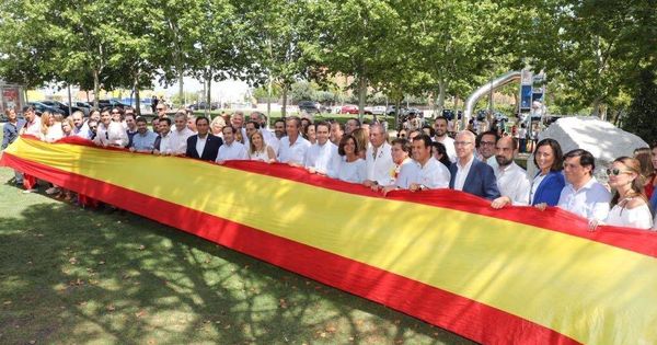 Foto: Representantes del PP sostienen una bandera gigante (PP Madrid)