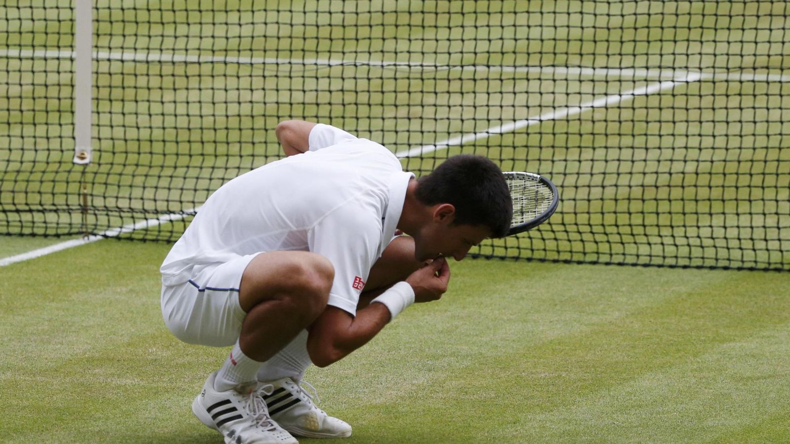 Foto: Novak Djokovic comiéndose la hierba de Wimbledon (Reuters).